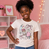 Cream t-shirt with coquette school collage of coffee, notebook, and bows